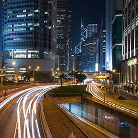 City scape at night, illuminated skyscrapers, city roads.