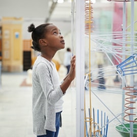 Girl standing next to a creative science installation.